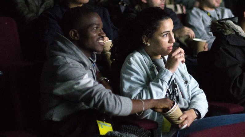 young people eating pop corn in the cinema