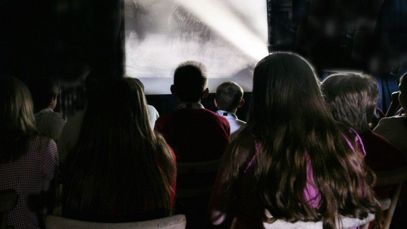 Young people watching old film in a club