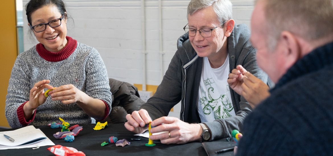 Education ambassadors in discussion while creating claymation characters