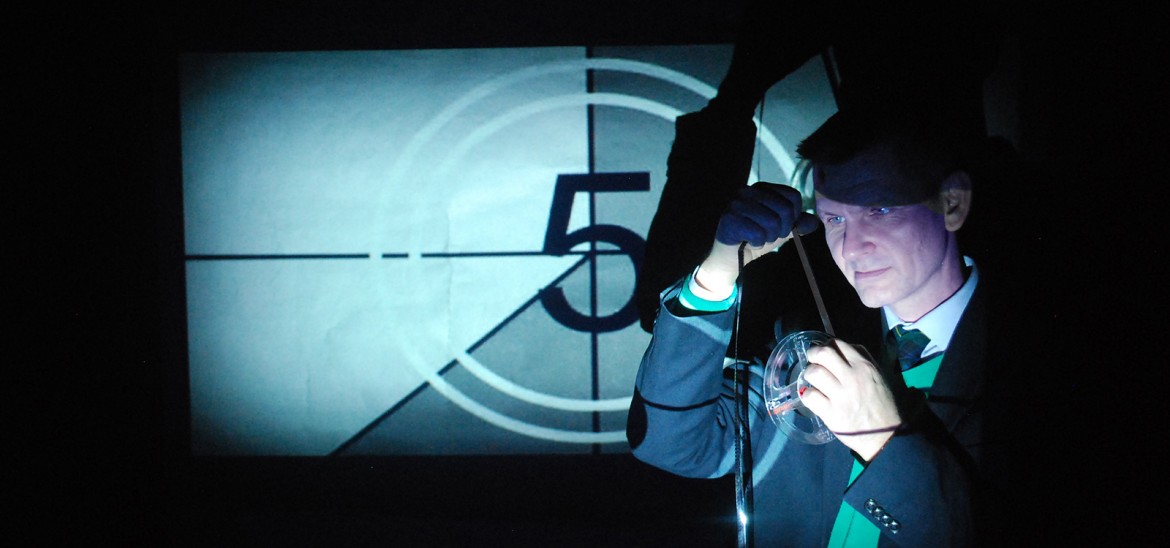 Educator examining a film reel in front of an old on-screen countdown still