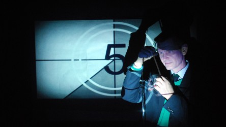 Educator examining a film reel in front of an old on-screen countdown still