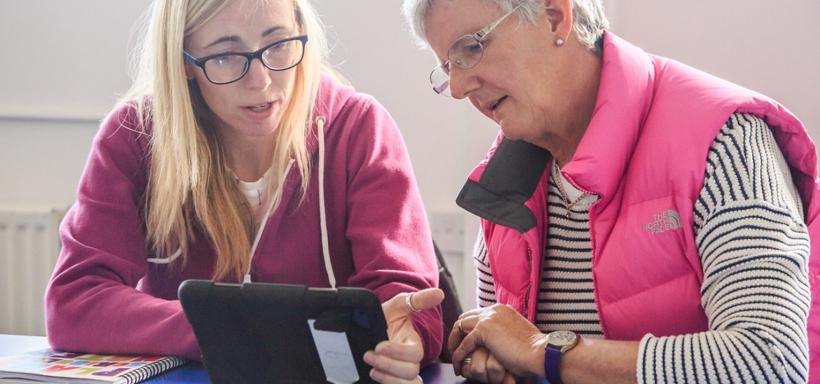 Two educators browsing on an ipad while chatting