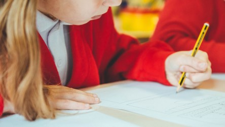 Young person writing a film review with pencil 